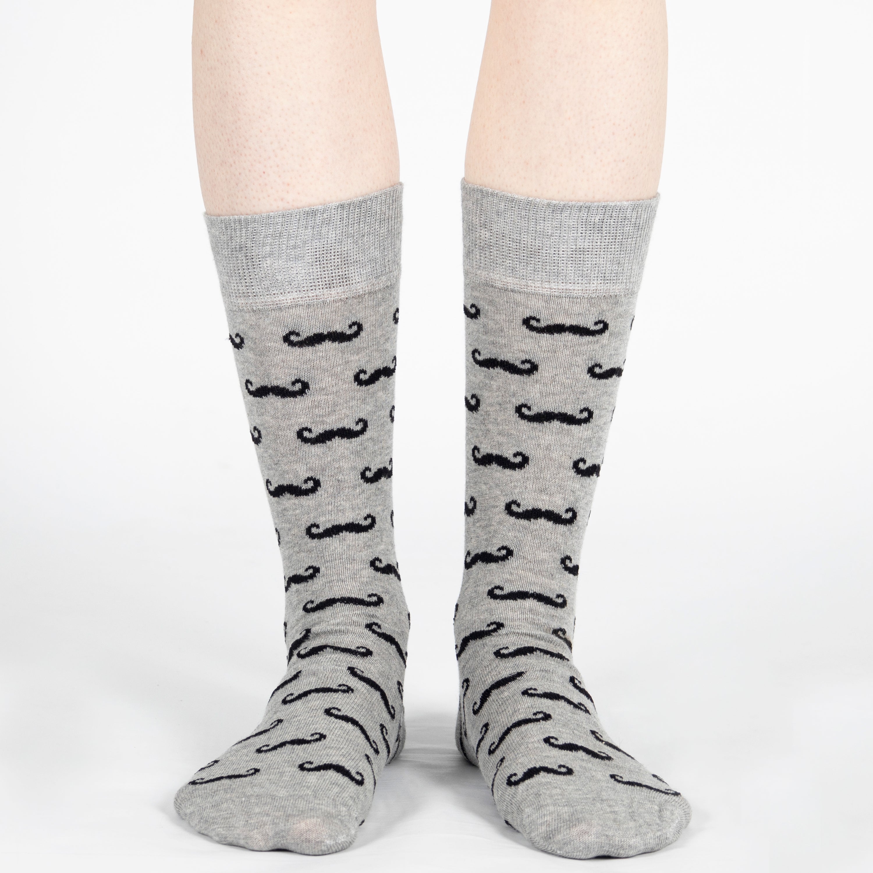 Gray socks with black mustache pattern worn by a person on a white background