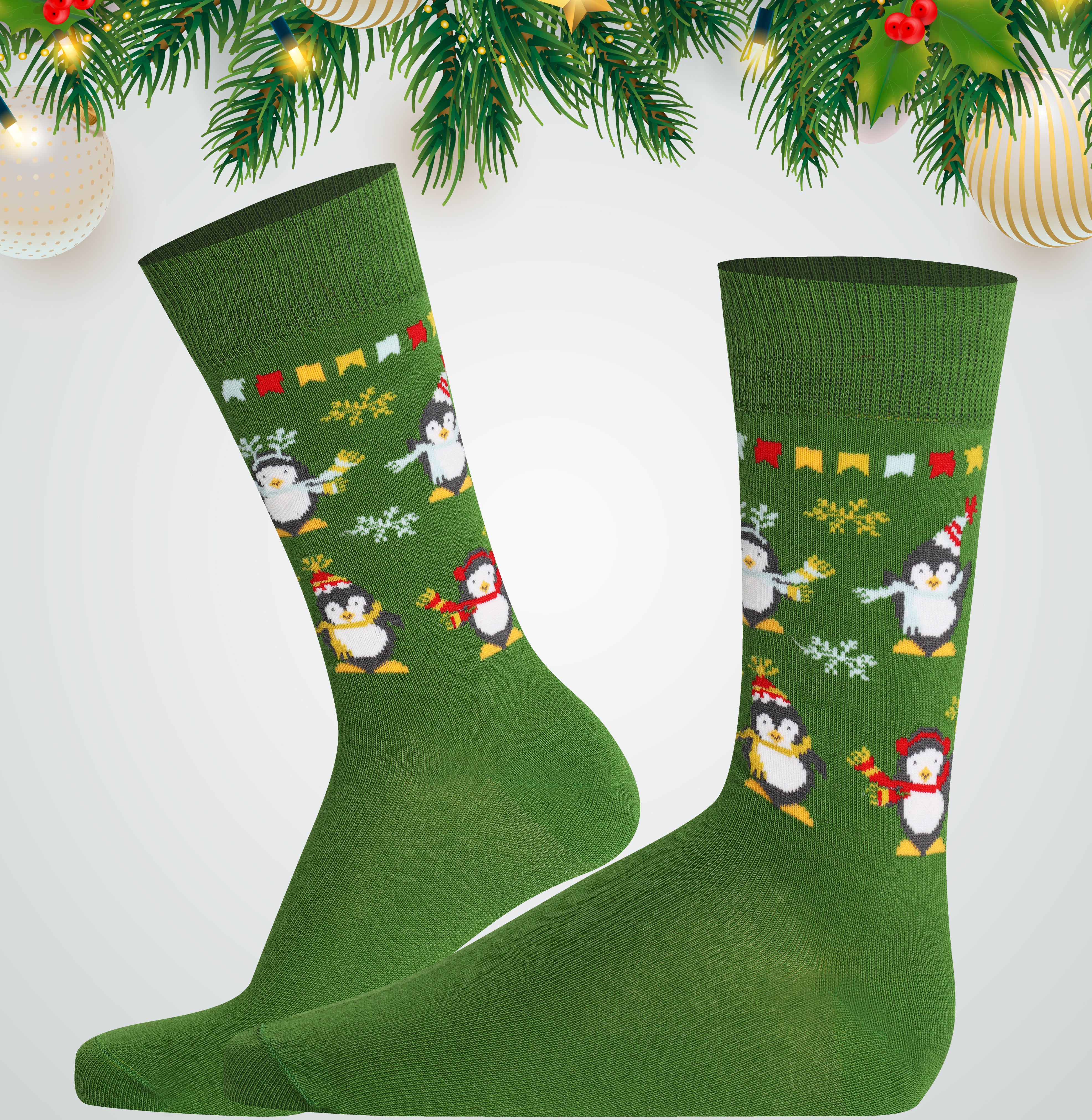 Green socks with penguin design on a white background with Christmas decorations.