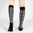 Tartan knee-high socks worn by a person on a white background
