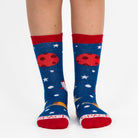 Blue socks with space-themed designs and red accents worn by a person on a white background