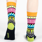 Pair of unisex Mysocks Aztec crew socks featuring vibrant geometric patterns in teal, yellow, and green, displayed on a white background.