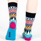 Pair of unisex Mysocks Aztec crew socks featuring vibrant geometric patterns in teal, yellow, and green, displayed on a white background.