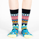 Pair of unisex Mysocks Aztec crew socks featuring vibrant geometric patterns in teal, yellow, and green, displayed on a white background.