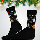 Black socks with penguin design on a white background with Christmas decorations.